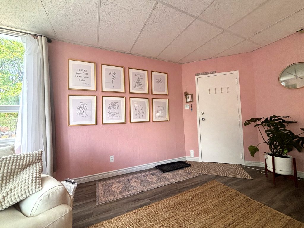 The Newmarket therapy office: gallery wall of framed prints, sofa and doorway